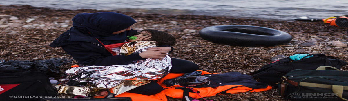 Sieviete no Sīrijas sēž Lesbos pludmalē, turot savu meitu, pēc tam, kad ar piepūšamo laivu, kas ir pilns ar bēgļiem un migrantiem, sasniedzis salu, šķērsojis daļu Egejas jūras no Turcijas uz Grieķiju.